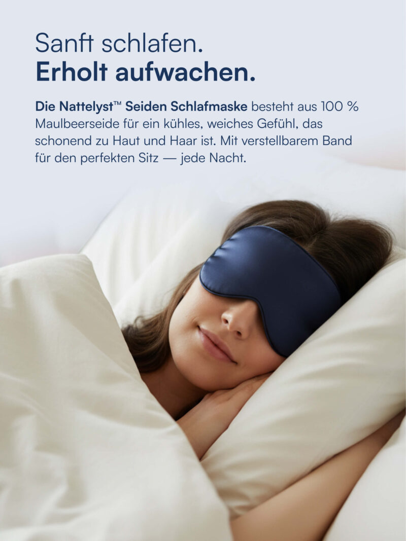Schlafende Frau mit dunkelblauer Seiden-Schlafmaske, eingekuschelt in hellem Bett unter weißer Bettdecke