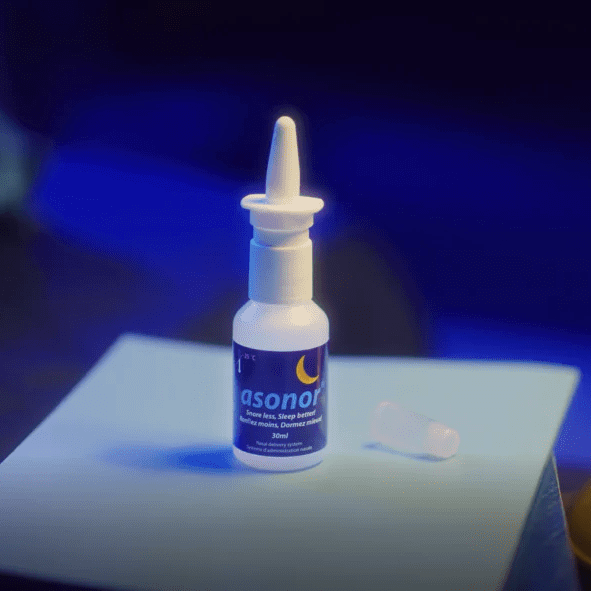 Kleine Nasenspray-Flasche mit blauem Asonor-Etikett und abgesetzter Kappe auf hellem Untergrund, blaues Licht